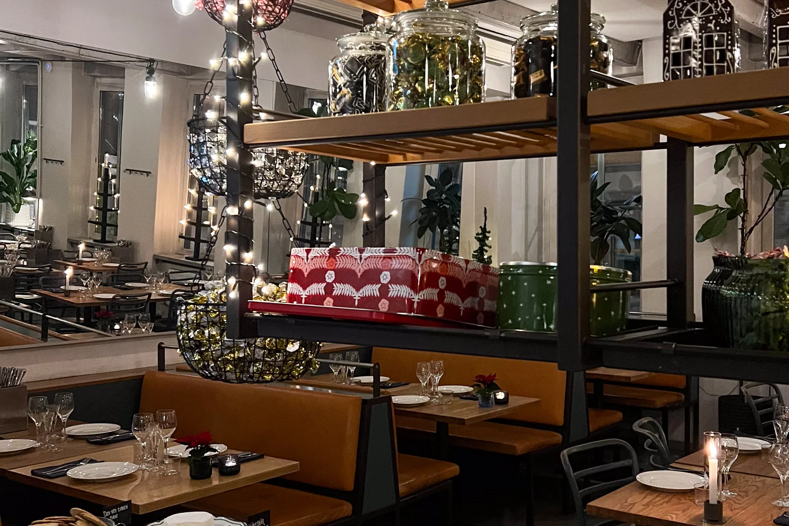 Matsalen klädd för december, med ljusslingor över hyllan och dukade bord